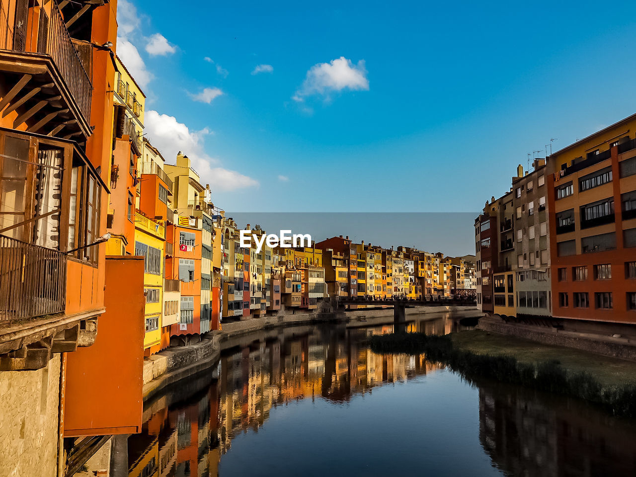 Reflection of buildings in canal against sky