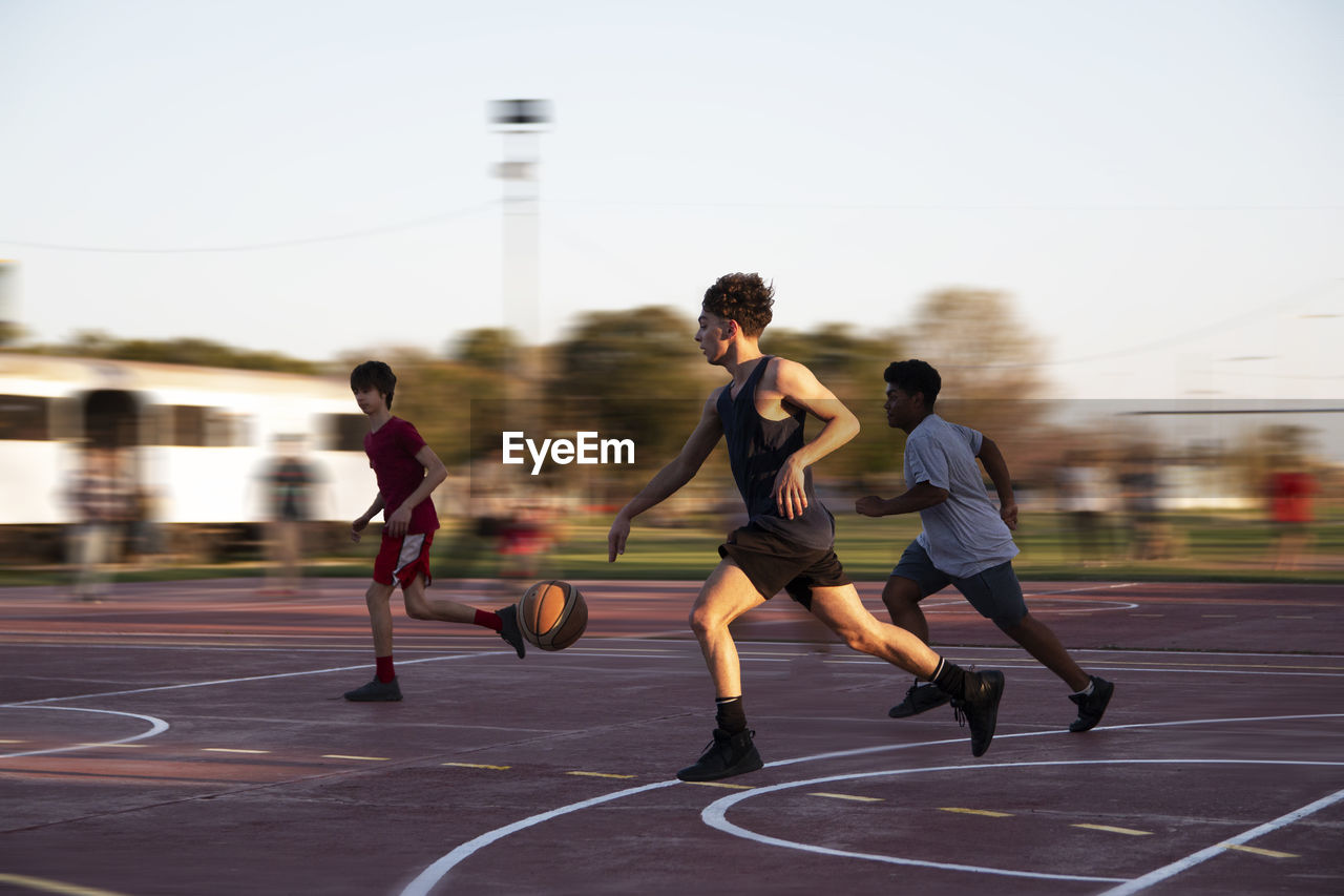 Teenagers playing street basketball