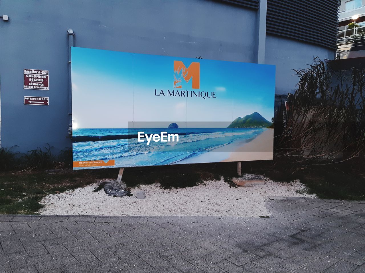 ROAD SIGN ON STREET AGAINST WALL