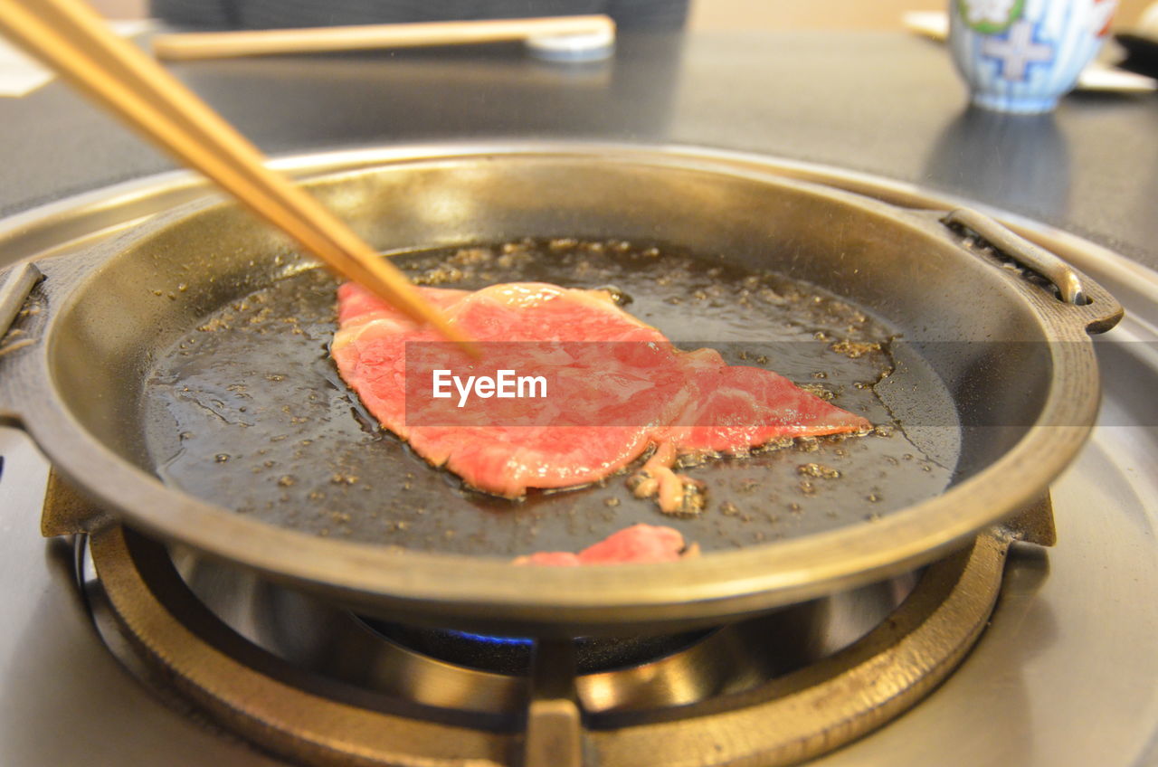 Preparation of sukiyaki in pan on gas stove