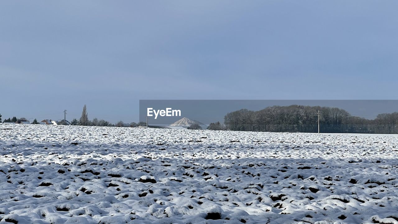 Surface level of snow covered land against sky