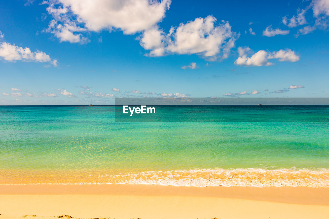 SCENIC VIEW OF BEACH AGAINST BLUE SKY