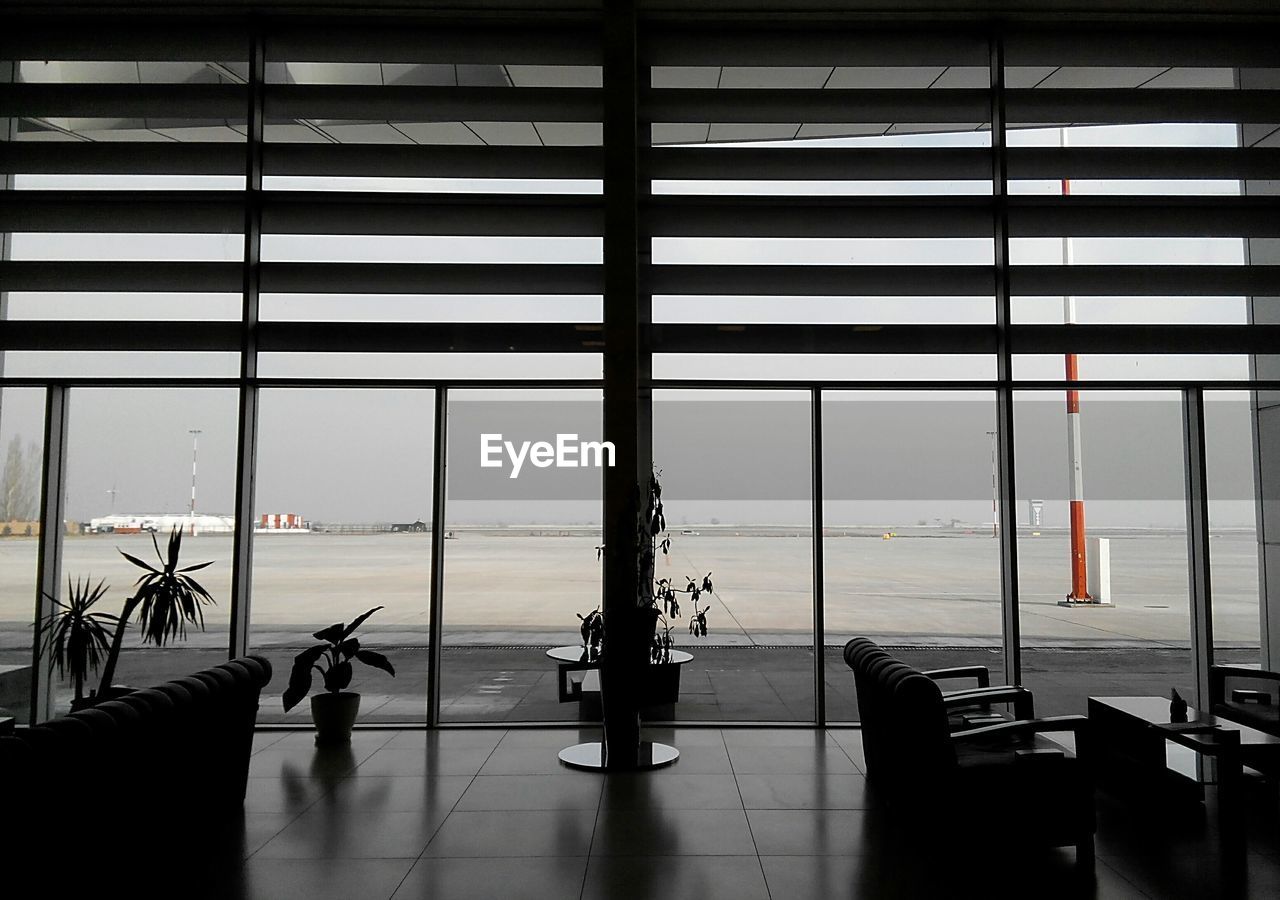 Airport runway seen through glass window