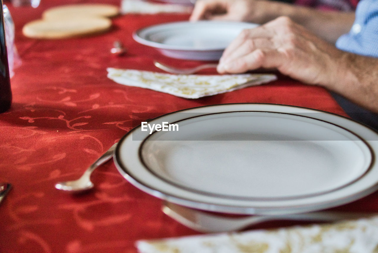 Midsection of man sitting by dining table