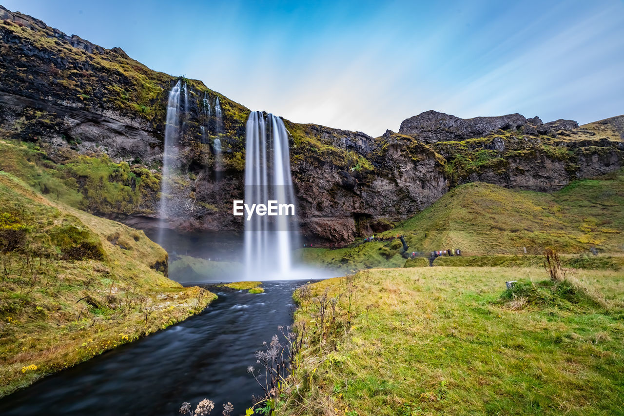 Scenic view of waterfall against sky