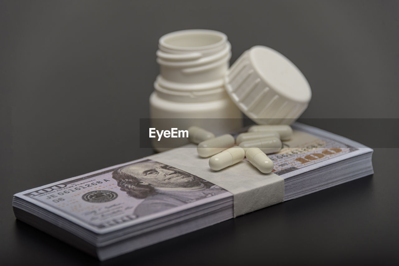 drug, pharmaceutical drug, studio shot, medicine, indoors, wealth, healthcare and medicine, money, finance, pill, dose, currency, business, no people, paper currency, large group of objects, cash, container