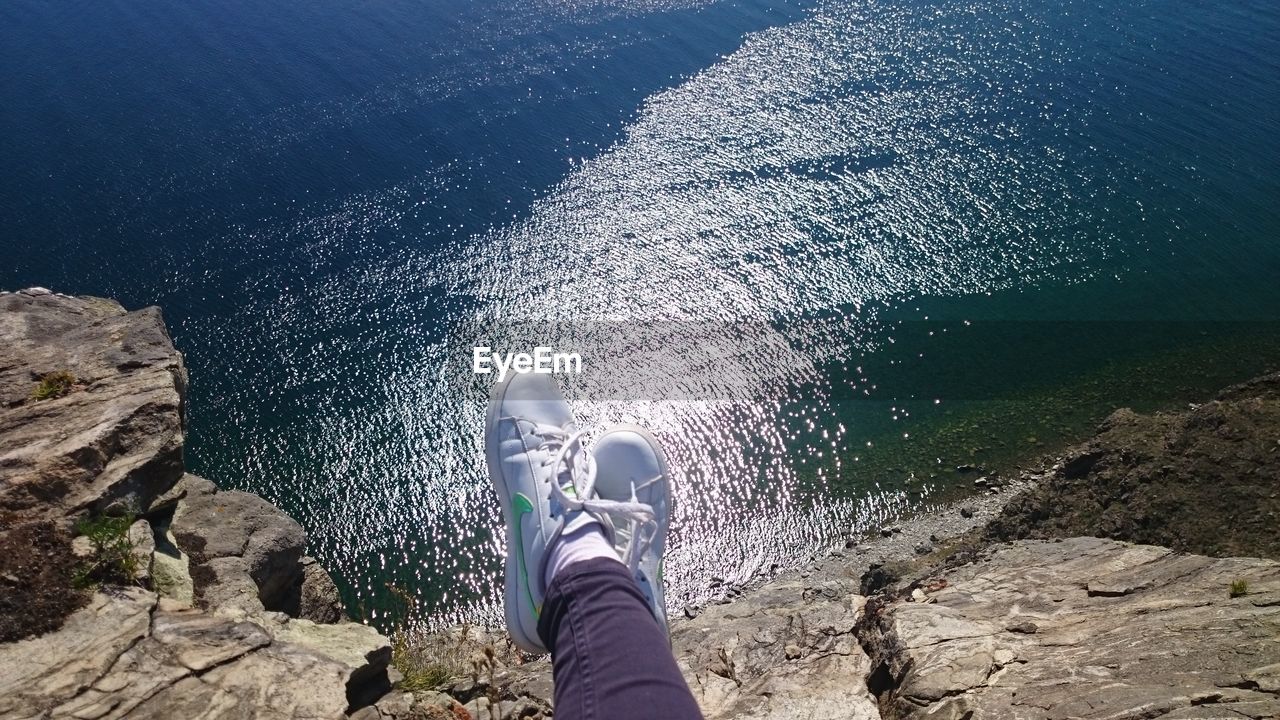 LOW SECTION OF WOMAN SITTING ON WATER