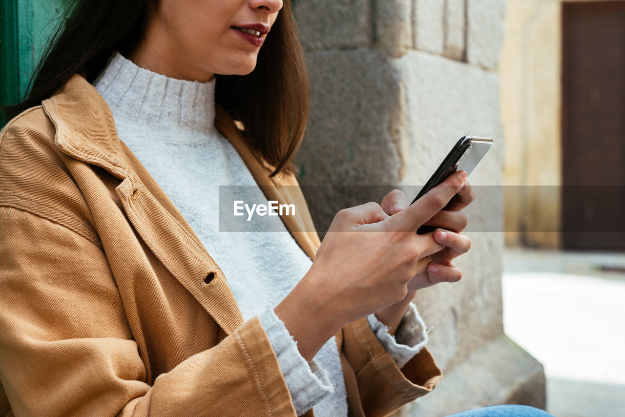 Close up of woman texting a message outdoors