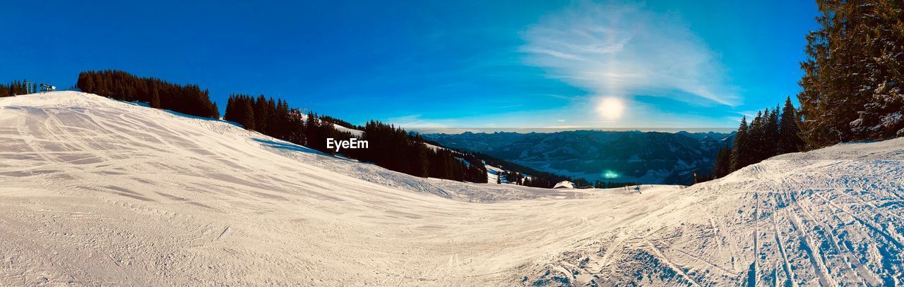 Scenic view of snowcapped mountains against blue sky