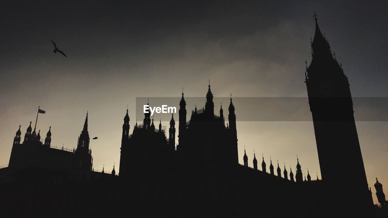 LOW ANGLE VIEW OF SILHOUETTE BUILDINGS AGAINST SKY