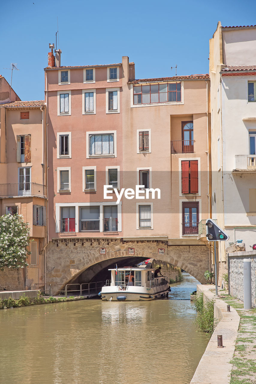 ARCH BRIDGE OVER RIVER BY BUILDINGS IN CITY