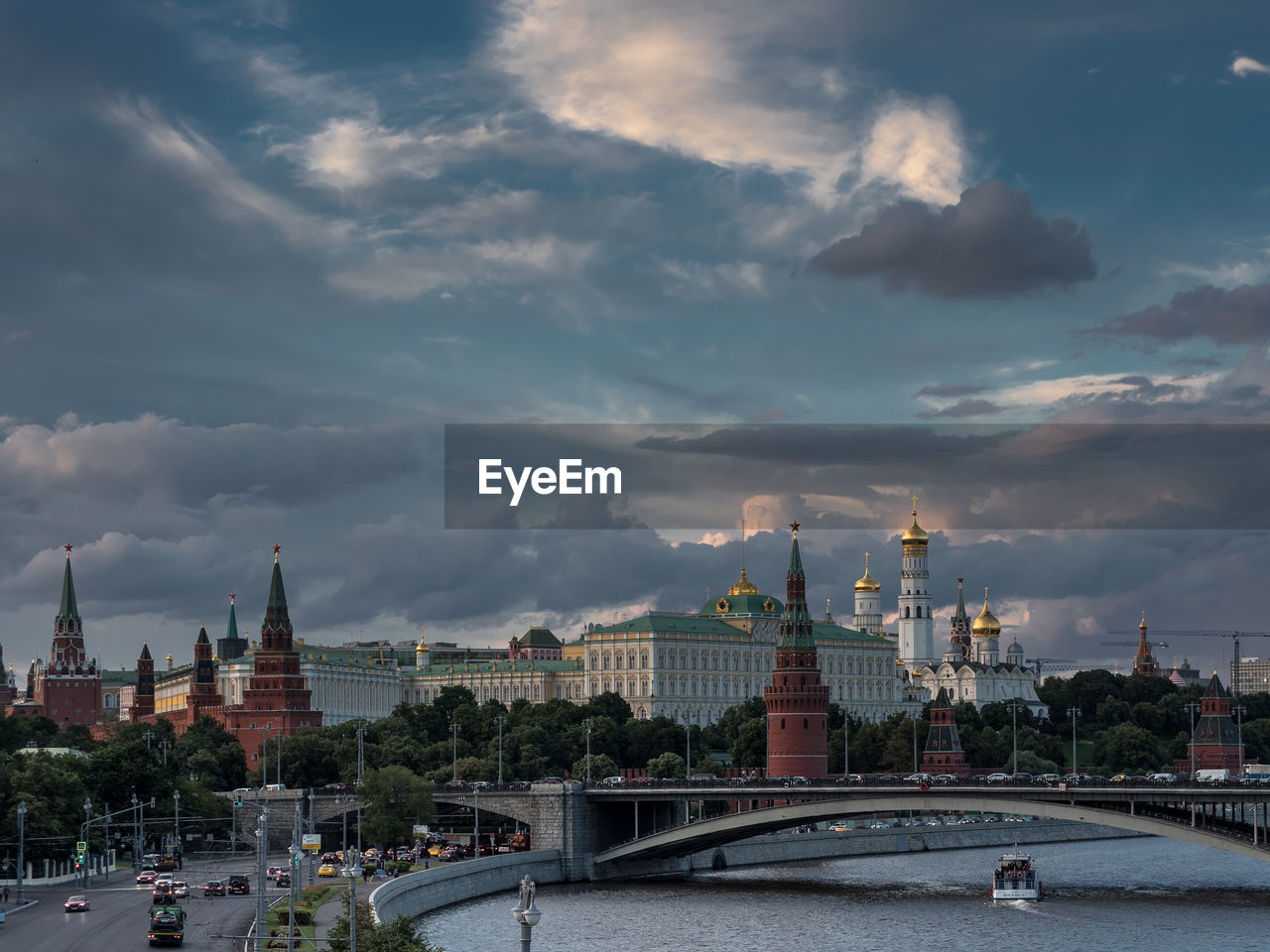 Spasskaya tower by moscva river against cloudy sky