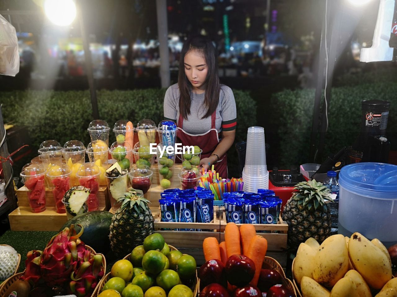WOMAN WITH FRUITS AT MARKET STALL