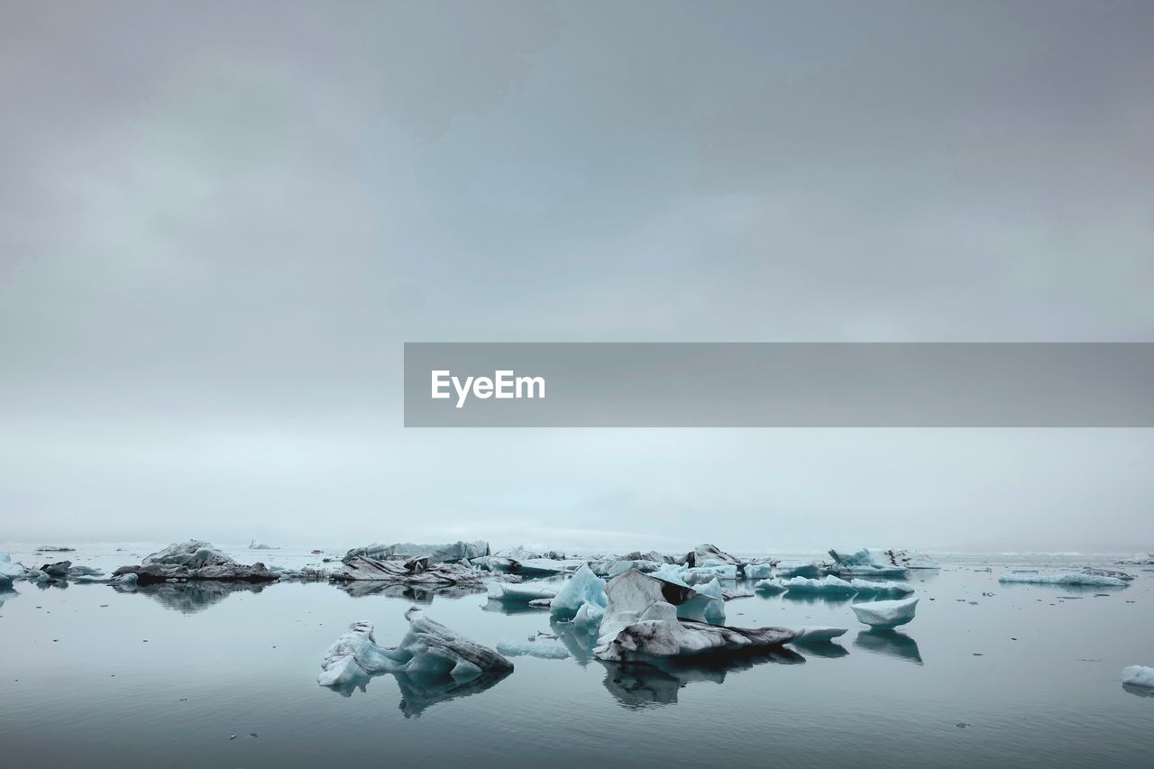 FROZEN LAKE AGAINST SKY