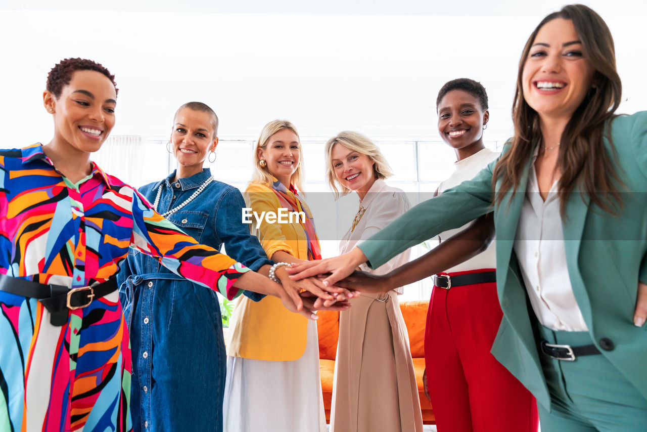 portrait of smiling friends standing against white background