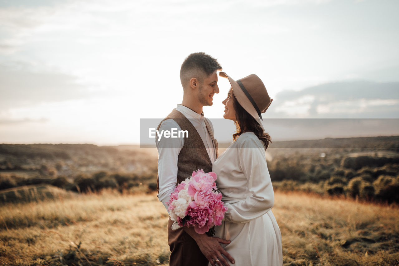 Couple standing on land against sky