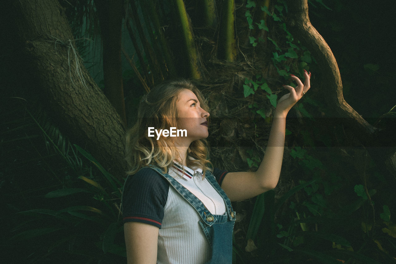 Young woman standing at forest