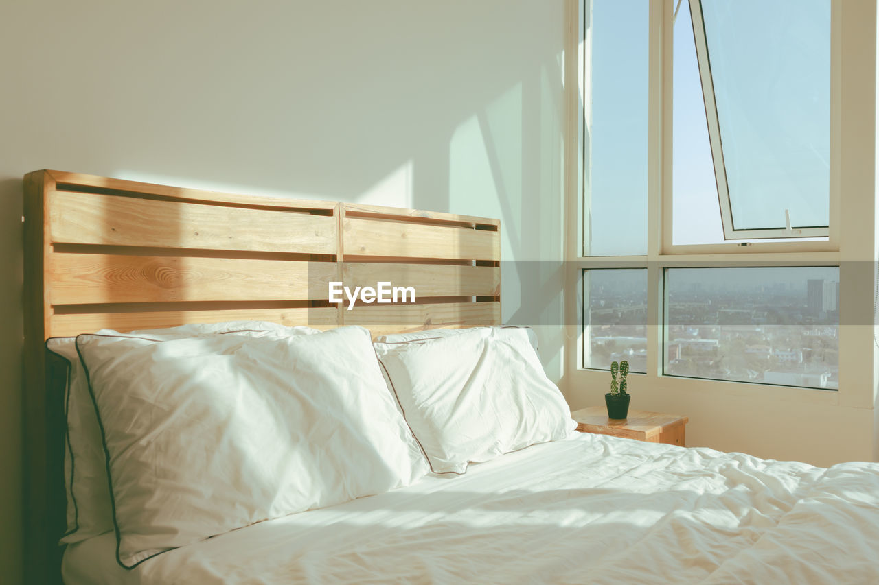 Loft white bedroom with soft sunlight of winter morning.