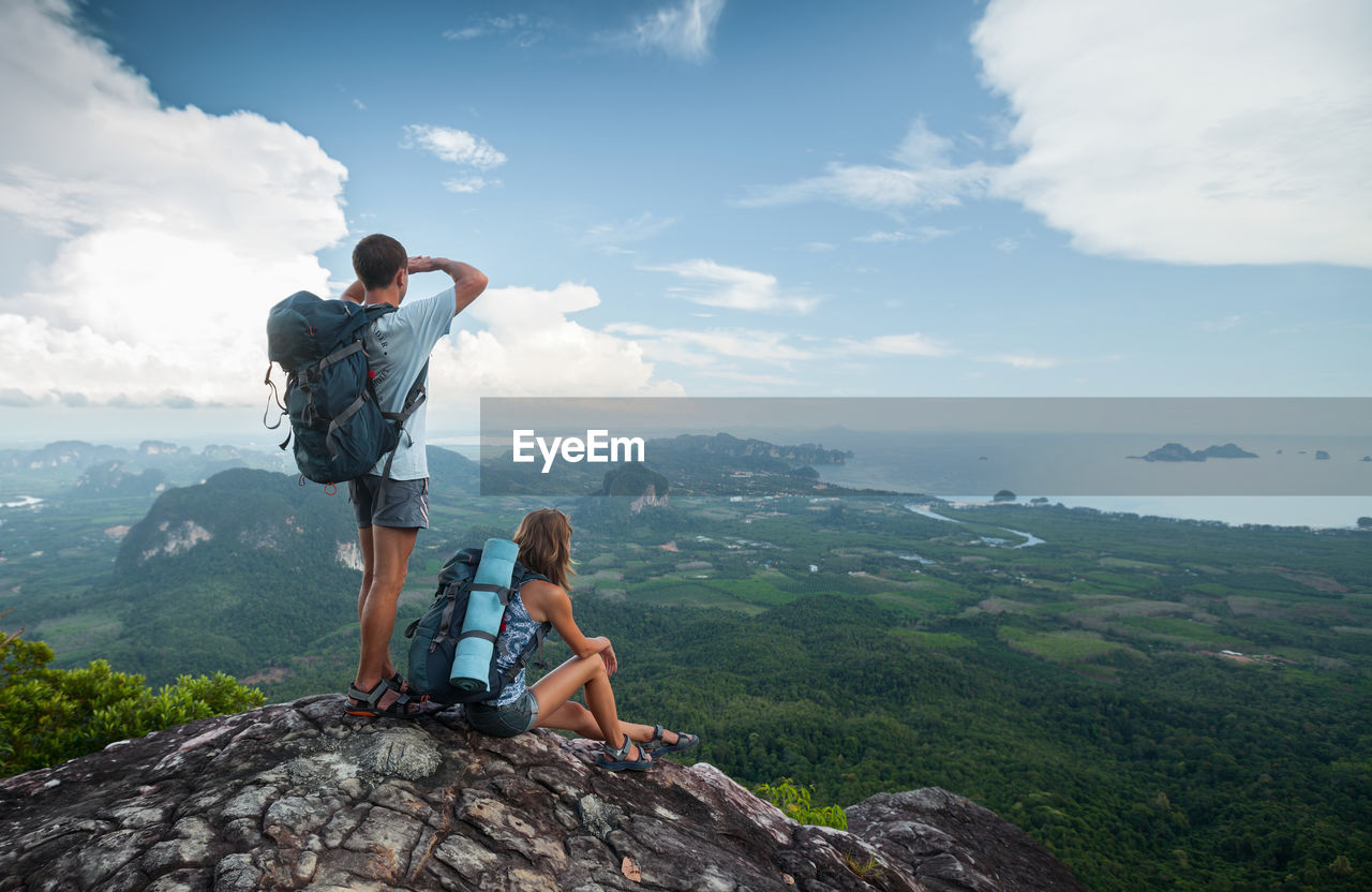 Young man looking at mountain against sky