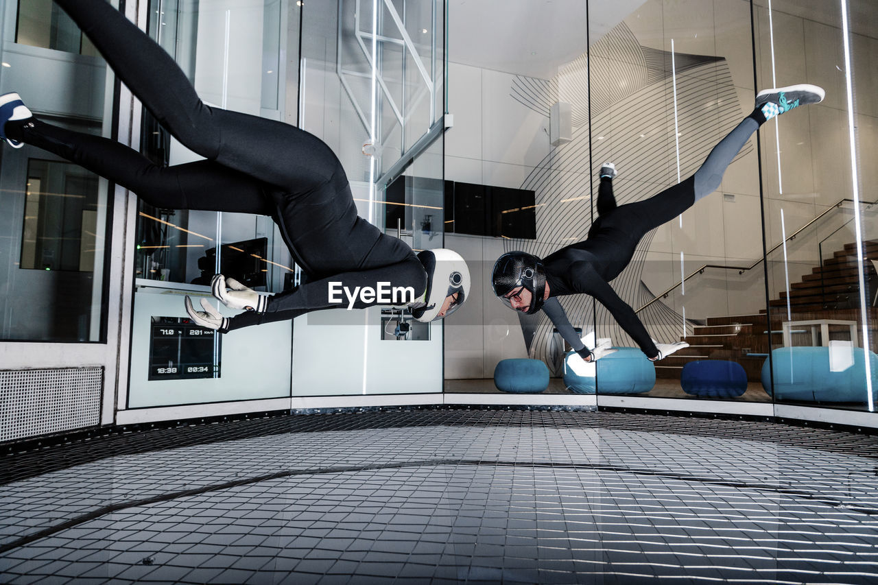 Woman with friend flying in wind tunnel