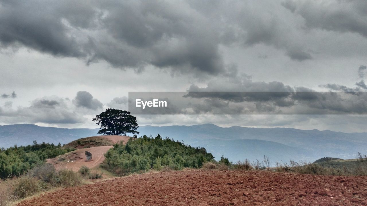 Scenic view of mountains against cloudy sky