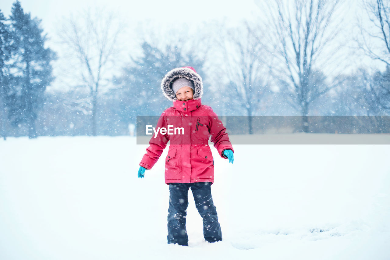 Full length of girl standing on snow covered land