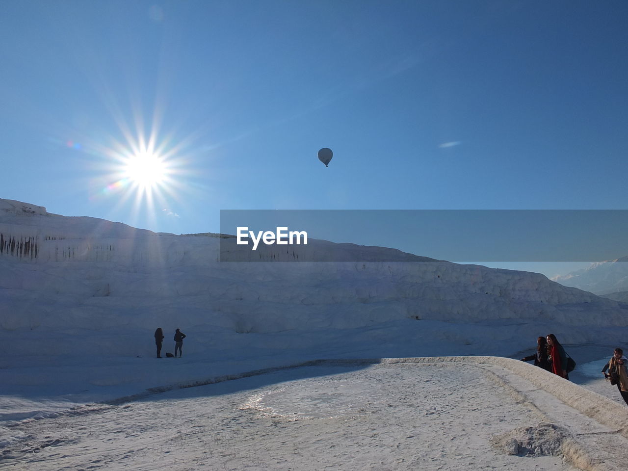 PEOPLE ON LAND AGAINST MOUNTAIN