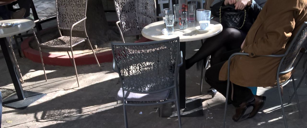 LOW SECTION OF MAN STANDING ON CHAIRS