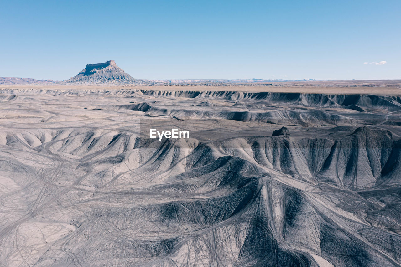 Aerial view of off-road atv tracks of swing arm city in torrey, utah. factory butte in distance.