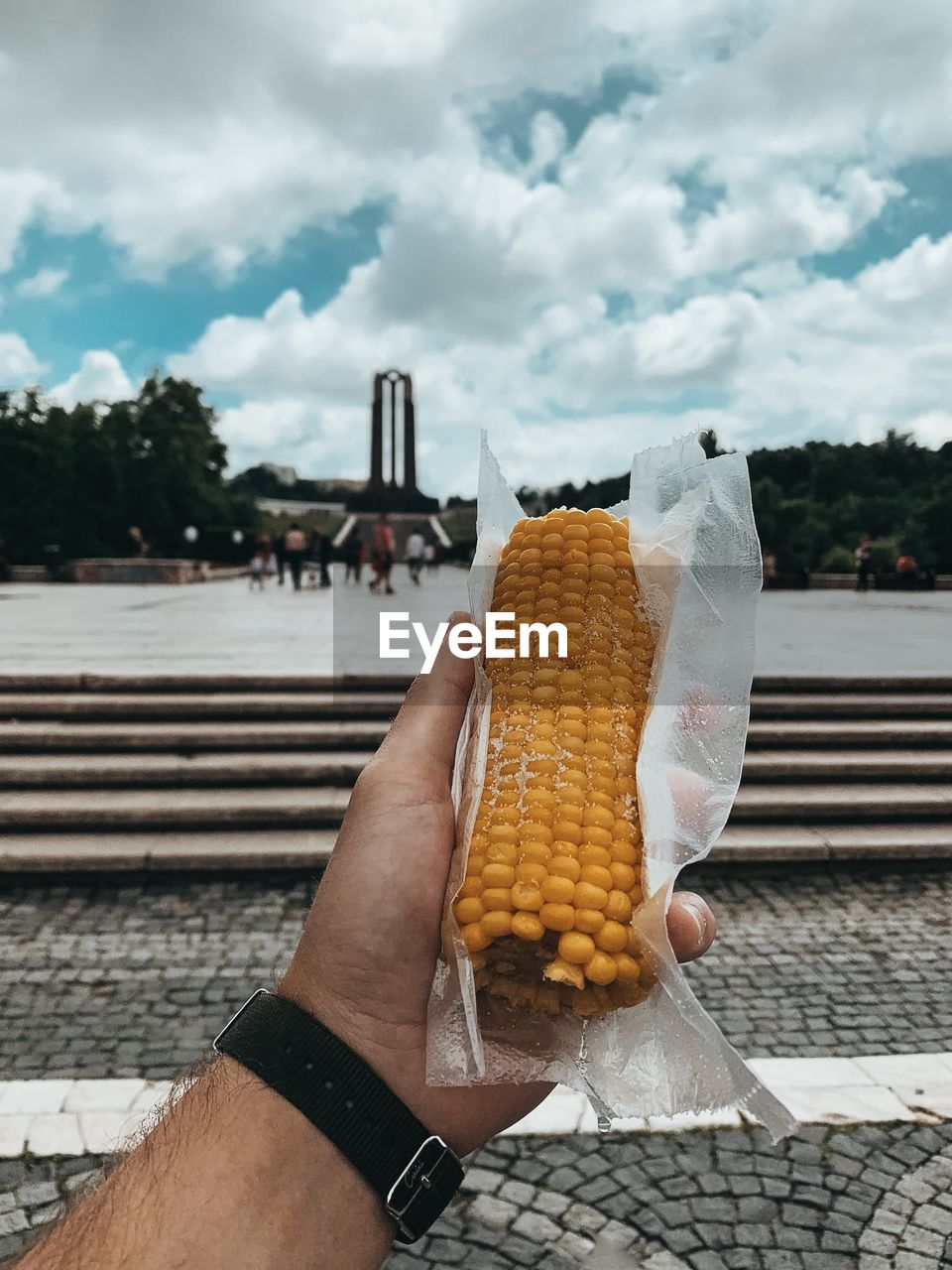 CROPPED IMAGE OF PERSON HOLDING ICE CREAM AGAINST SKY