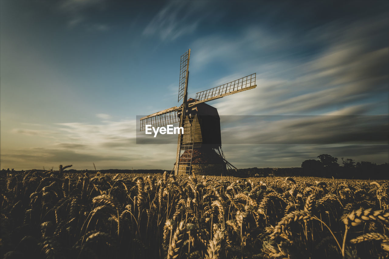 Traditional windmill on field against sky