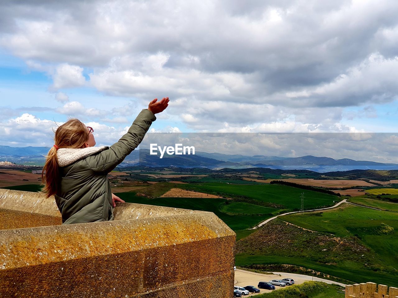 Girl standing at observation point against cloudy sky