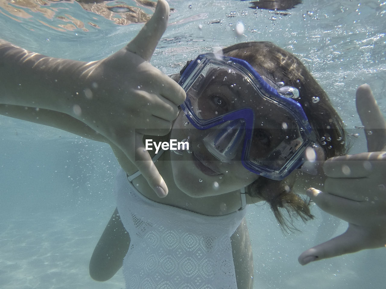 Close-up portrait of woman swimming underwater