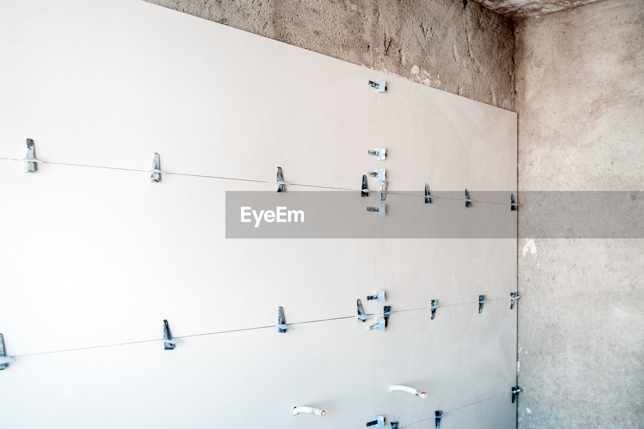 Construction site. white tiles on bathroom with separator and leveling during works. home renovation