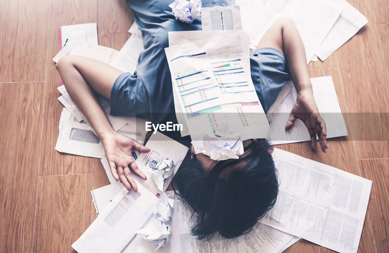 HIGH ANGLE VIEW OF WOMAN USING SMART PHONE ON TABLE