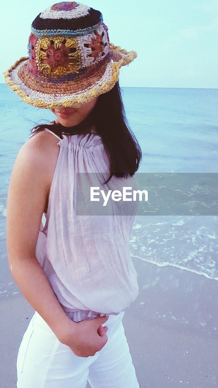 High angle view of woman with knit hat standing at beach