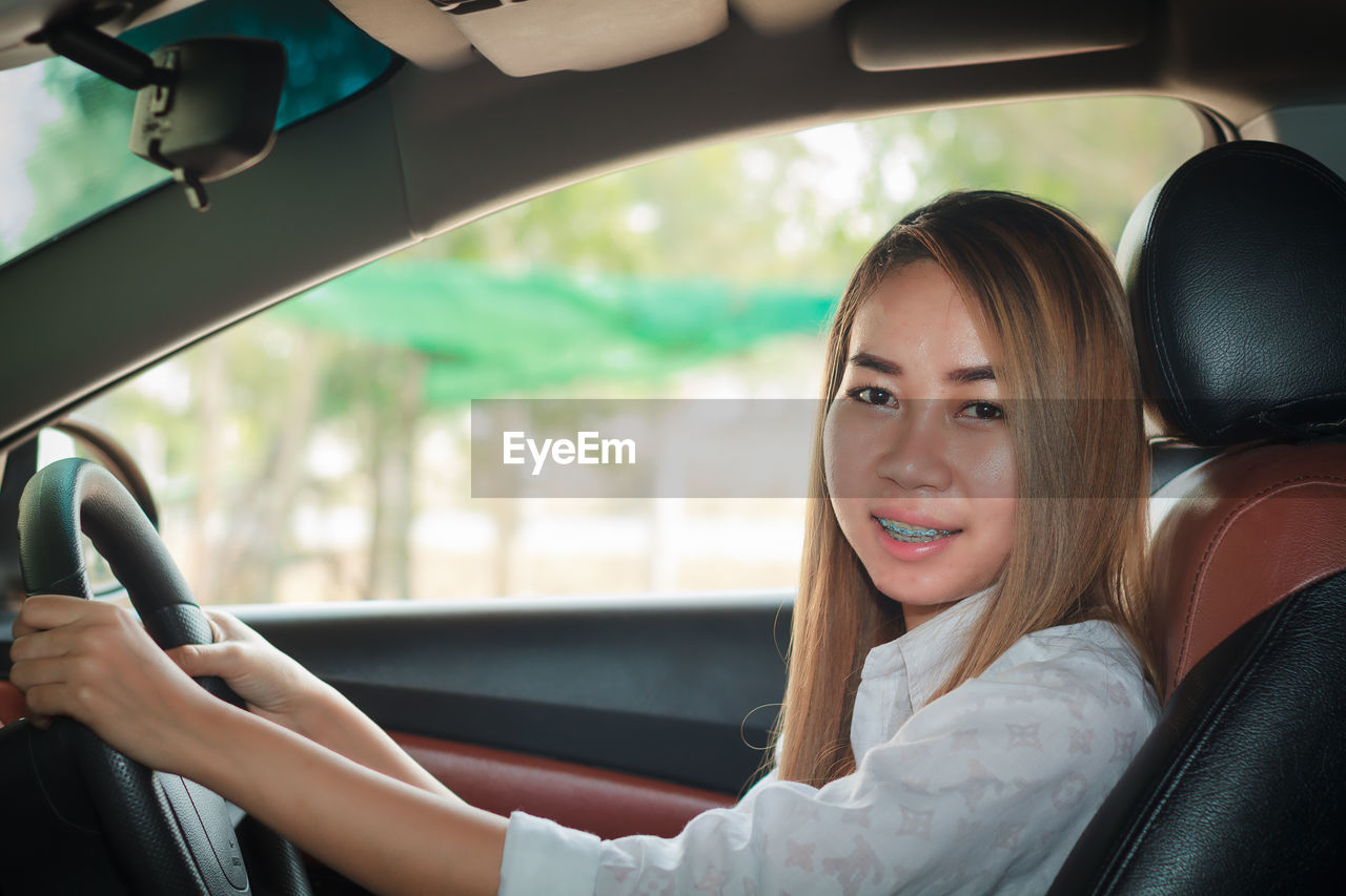 Portrait of smiling woman in car