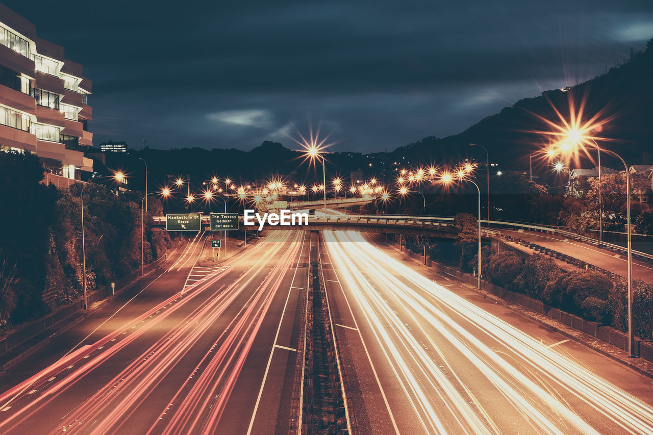 Light trails on road against sky at night