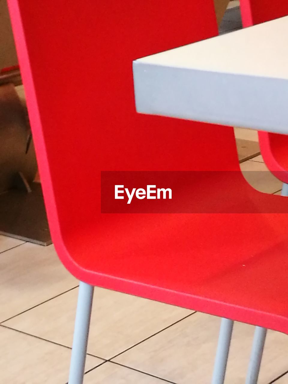 HIGH ANGLE VIEW OF RED CHAIR ON TILED FLOOR