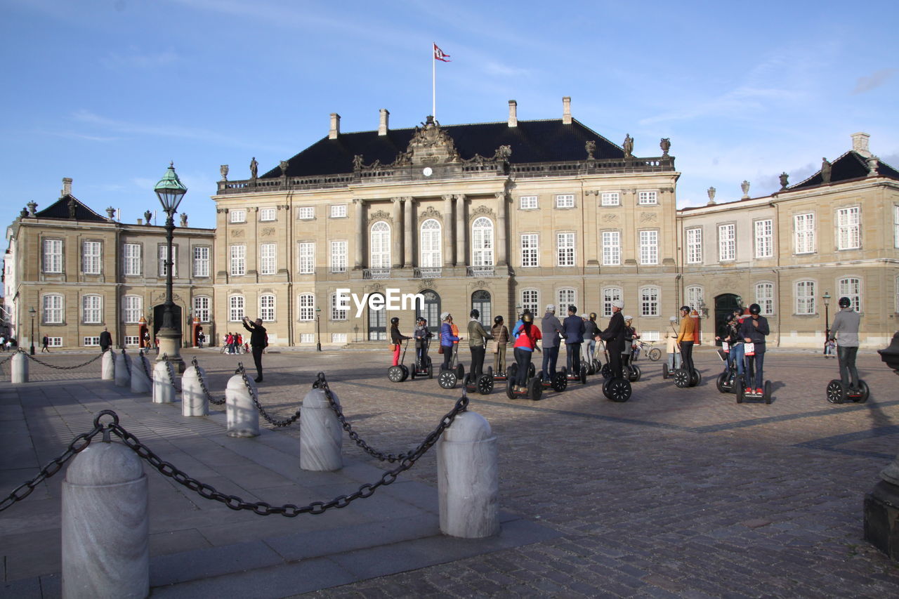 GROUP OF PEOPLE IN FRONT OF BUILDINGS