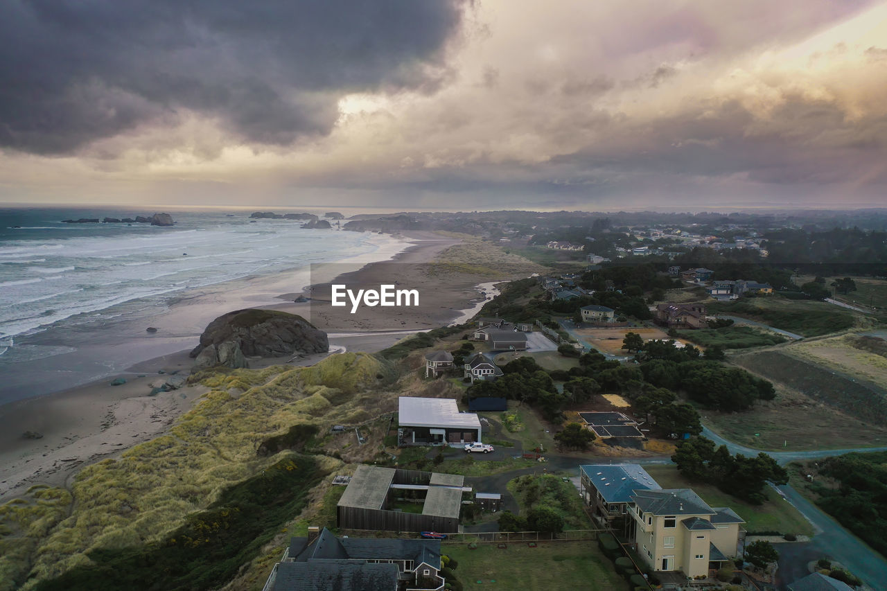 Coastal homes and vacation rentals in bandon, oregon coast with storm clouds in sky.