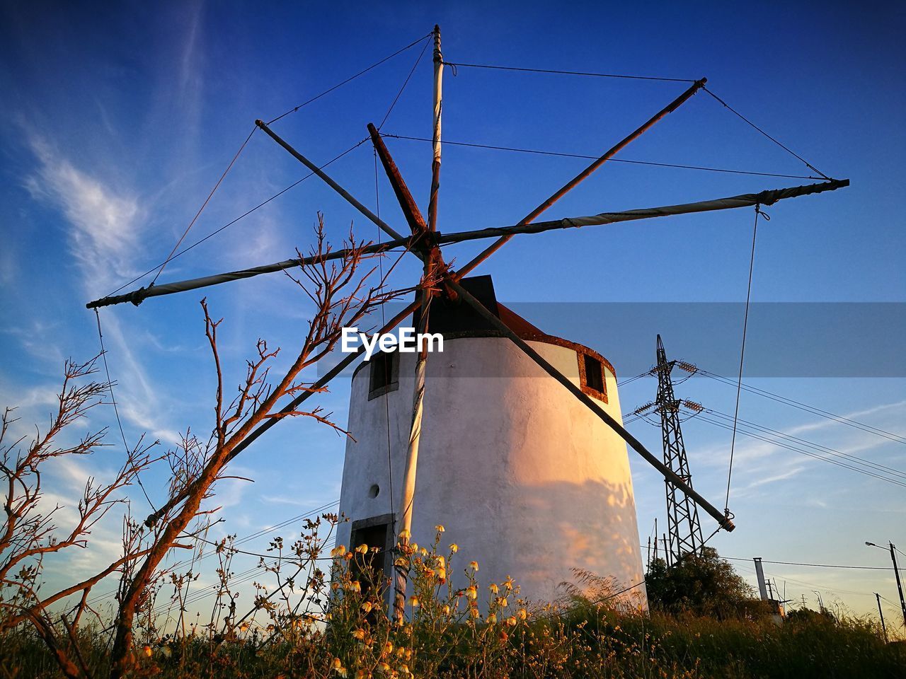 Low angle view of windmill on field against sky