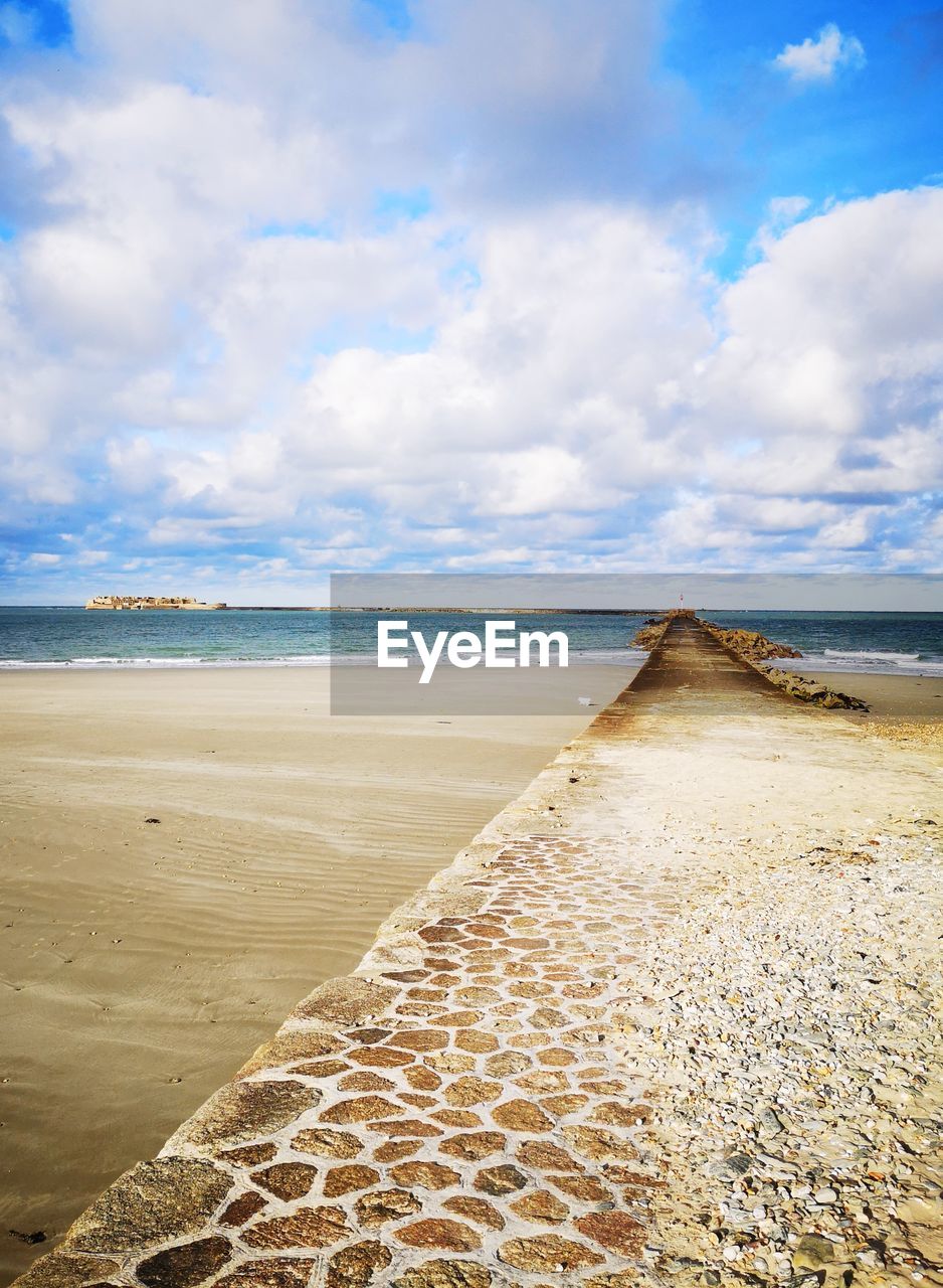 SCENIC VIEW OF BEACH AGAINST CLOUDY SKY