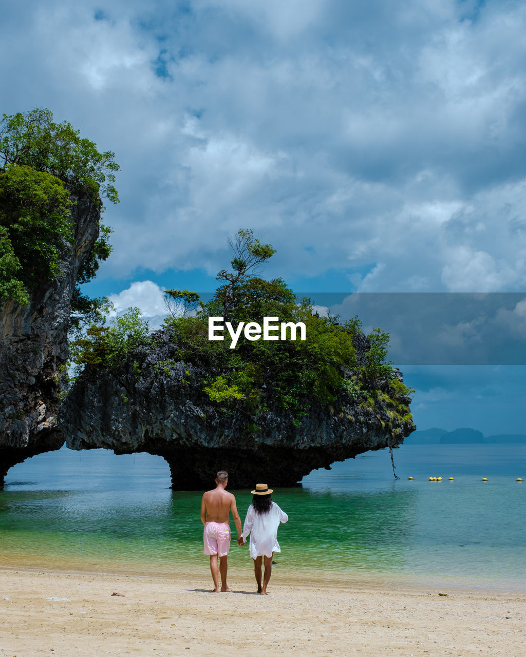 rear view of woman walking at beach against sky