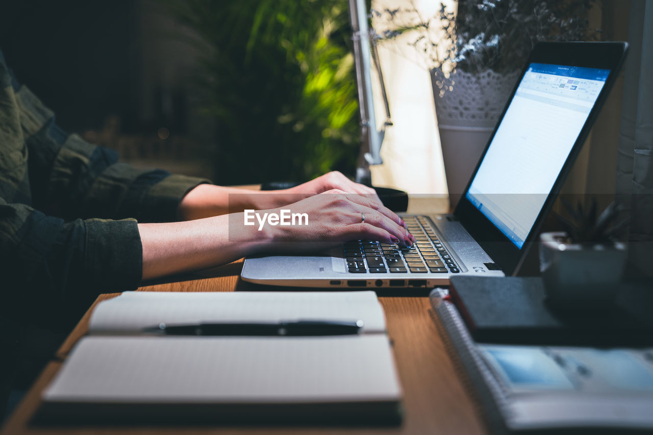 Woman hands typing on laptop on table. focus on hands typing. work from home concept