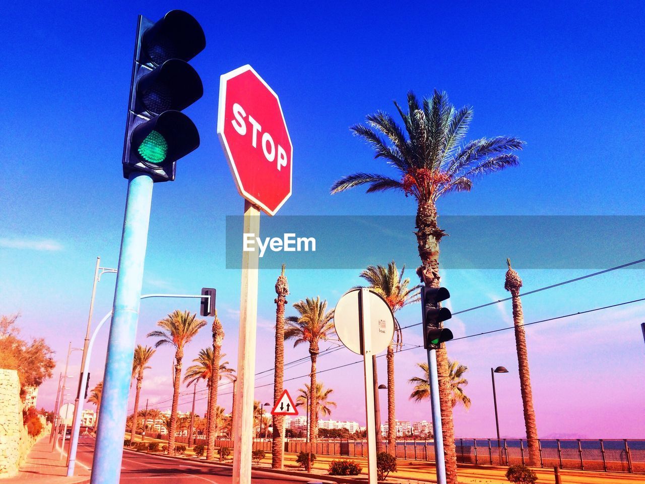 Stop sign and traffic lights against sky