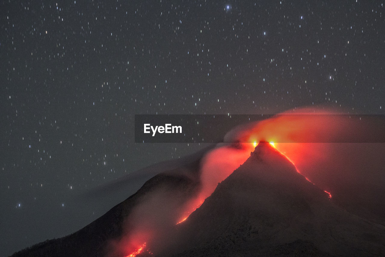 Scenic view of volcanic crater against star field at night