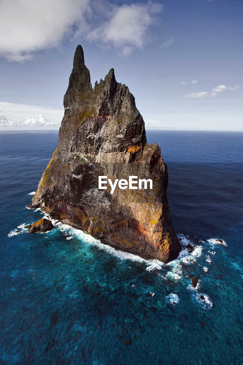 Rock formation in sea against sky