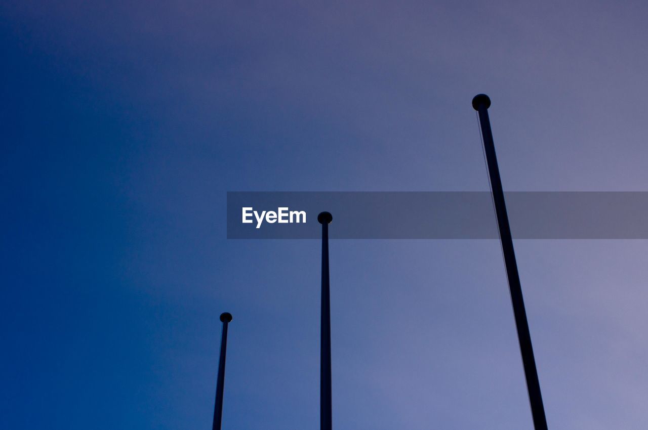 LOW ANGLE VIEW OF STREET LIGHTS AGAINST CLEAR BLUE SKY