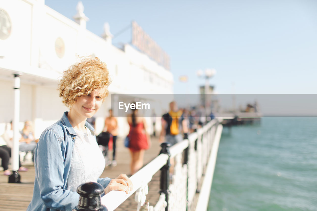 Portrait of woman at brighton pier against sky